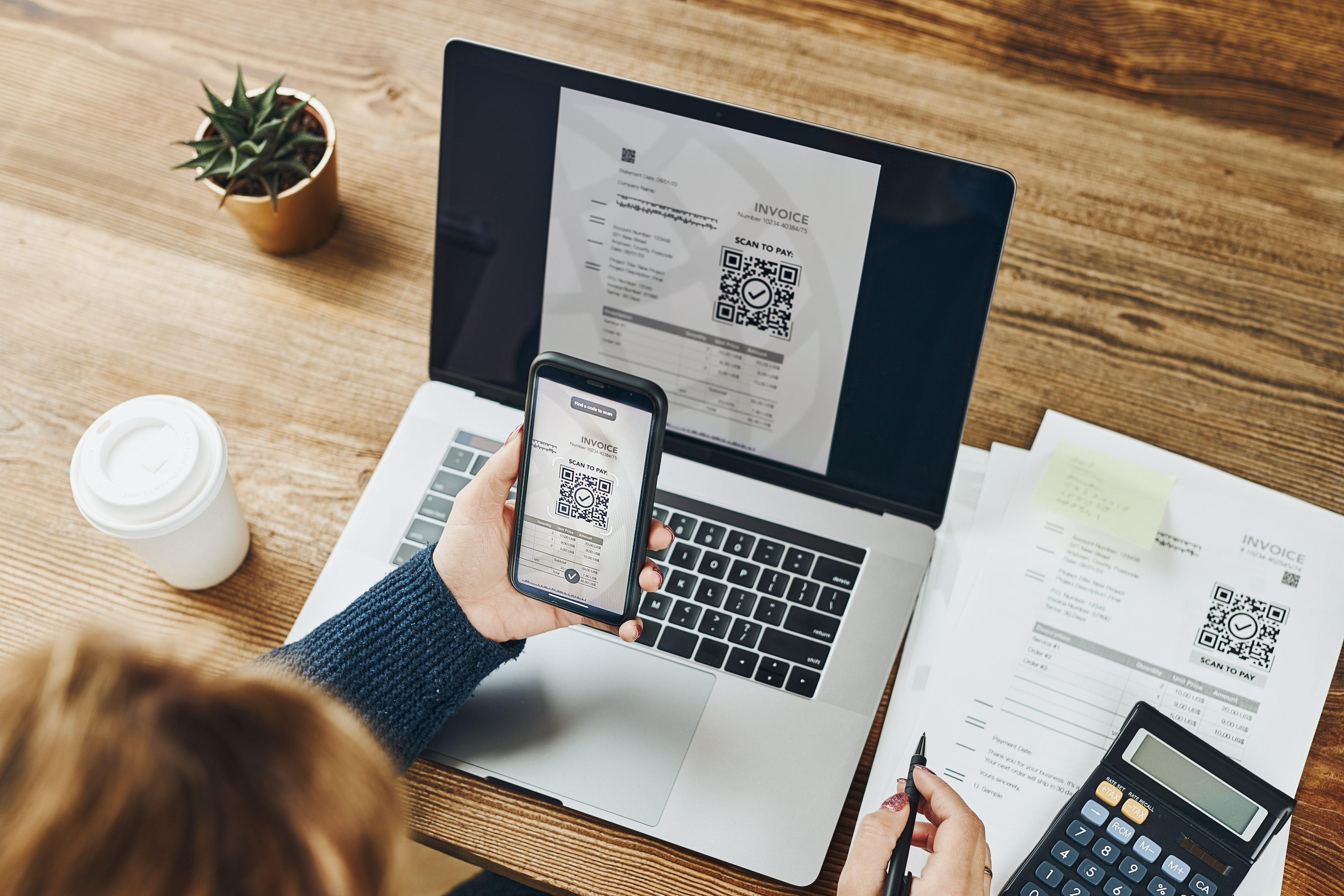 Laptop und Handy mit einer Rechnung und QR-Code